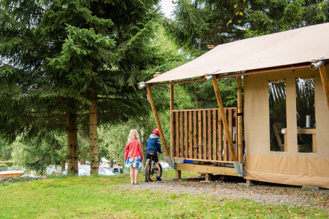 Niños cerca de la tienda safari en la naturaleza - Camping Petit Suisse - Manhay, Luxemburgo, Bélgica
