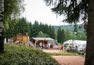Famiglie al parco giochi circondato dalla foresta nel villaggio vacanze Petite Suisse, Belgio Lussemburgo.