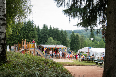 Famiglie al parco giochi circondato dalla foresta nel villaggio vacanze Petite Suisse, Belgio Lussemburgo.