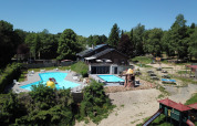 Vue aérienne des piscines, aire de jeux et tables de pique-nique au parc de vacances Petite Suisse en Belgique Luxembourg.