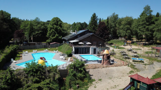 Luchtfoto van zwembaden, speeltuin en picknicktafels bij vakantiepark Petite Suisse in Belgisch Luxemburg.
