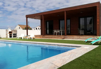 Außenansicht der Lodge Casa Toria in Spanien mit eigenem Pool, Sonnenliegen, Grill und Holzterrasse.