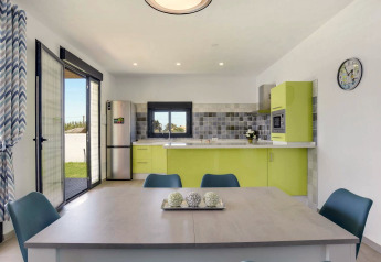 Moderne Küche und Essbereich in der Casa Toria Lodge in Spanien mit grünen Schränken und viel Licht.