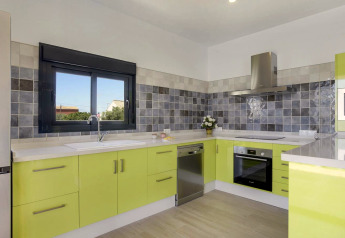 Modernes Küche mit limettengrünen Schränken, Fliesenspiegel und großem Fenster in Casa Toria, Spanien.