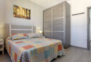 Schlafzimmer in der Casa Toria Lodge in Spanien mit Holzschrank, Doppelbett und hellem Dekor.