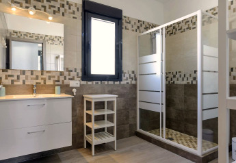 Modernes Bad im Casa Toria in Spanien mit großer Dusche, Fenster und stilvollem Waschbecken.