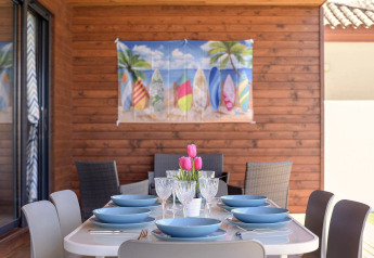 Gedeckter Esstisch im Freien bei Casa Toria in Spanien mit Surfbretter-Dekoration und Holzwand.