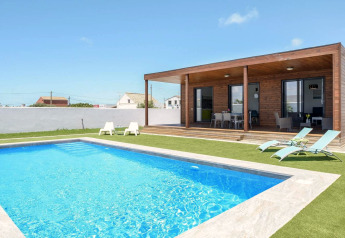 Casa Toria, eine moderne Lodge in Spanien, mit Pool, Liegestühlen, überdachter Terrasse und Garten.