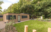 Chalet Cannenburch Deluxe au Veluwepark de Bosgraaf aux Pays-Bas, avec terrasse et jardin verdoyant.