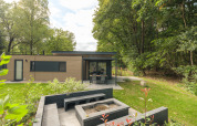 Moderne Cannenburch Deluxe lodge bij Veluwepark de Bosgraaf in Nederland met terras en buitenvuurplek.