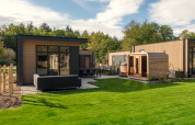 Moderne Lodge Essenburgh mit Whirlpool und Sauna im Veluwepark de Bosgraaf, Niederlande, umgeben von Natur.