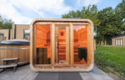 Buitensauna en hottub bij een lodge in Veluwepark de Bosgraaf, Nederland, omgeven door groen en natuur.