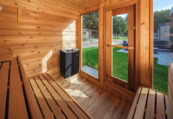 Vue intérieure d'un sauna en bois avec bancs et grandes fenêtres au Veluwepark de Bosgraaf, Pays-Bas.