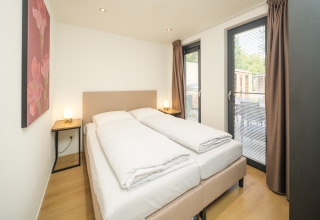 Camera da letto moderna della lodge Essenburgh con vasca idromassaggio e sauna al Veluwepark de Bosgraaf nei Paesi Bassi.