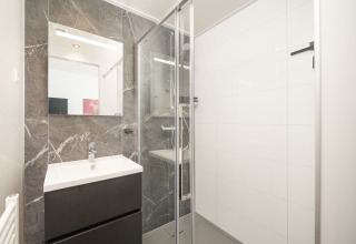 Bagno moderno nella lodge Essenburgh con doccia in vetro e lavandino, al Veluwepark de Bosgraaf.