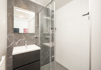 Bagno moderno nella lodge Essenburgh con doccia in vetro e lavandino, al Veluwepark de Bosgraaf.