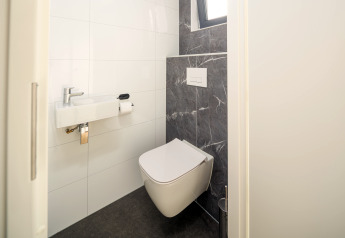 Modernes WC mit wandhängender Toilette und Waschbecken, Essenburgh Lodge, Veluwepark de Bosgraaf, Niederlande.