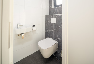 Moderne toilet med væghængt toilet og håndvask, Essenburgh lodge, Veluwepark de Bosgraaf, Holland.