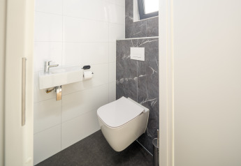 Toilettes modernes avec WC suspendu et petit lavabo, Essenburgh lodge, Veluwepark de Bosgraaf, Pays-Bas.