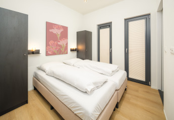 Modernes Schlafzimmer in der Essenburgh Lodge mit Doppelbett, stilvollem Dekor und heller Einrichtung im Veluwepark de Bosgraaf, Niederlande.