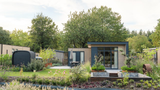 Photo du lodge Essenburgh Comfort avec jacuzzi, sauna, jardin paysager moderne et étang en pleine nature.