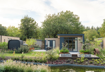 Foto della lodge Essenburgh Comfort con vasca idromassaggio, sauna, giardino moderno e laghetto naturale.