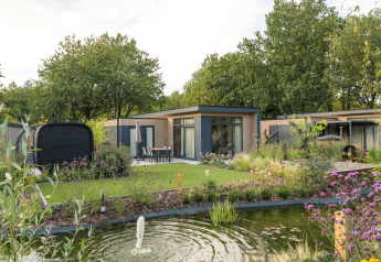 Lodge Essenburgh Comfort moderne avec bain à remous et sauna à Veluwepark de Bosgraaf, entouré de jardins.