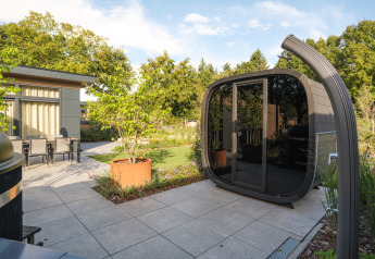 Moderne Gartenterrasse mit stilvoller Lodge, Glasfront und Sitzbereich im Essenburgh Comfort mit Hottub & Sauna im Veluwepark de Bosgraaf.