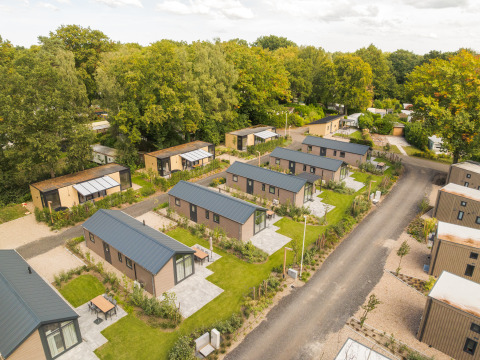 Luchtfoto van Doornenburg Lodge te Veluwepark de Bosgraaf in Nederland met moderne lodges en veel groen.
