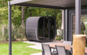 Modern lodge with outdoor sauna and patio set at Veluwepark de Bosgraaf, Netherlands, in a green setting.