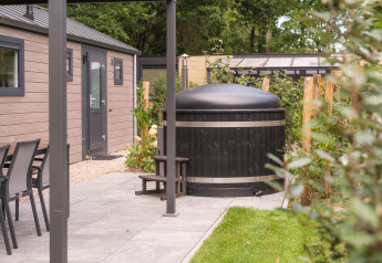 Udendørs scene ved Doornenburg Lodge Comfort med hottub og sauna på Veluwepark de Bosgraaf, Holland.