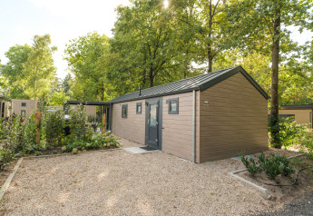 Exterior view of Doornenburg Lodge Comfort with hot tub and sauna at Veluwepark de Bosgraaf, Netherlands.