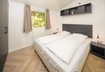 Camera moderna al Cozy Chalet di Veluwepark de Bosgraaf, Paesi Bassi, con letto matrimoniale e finestra.