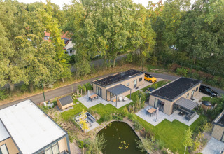 Luchtfoto van Loevestein Deluxe lodge met hottub & sauna aan een vijver in Veluwepark de Bosgraaf, Nederland.