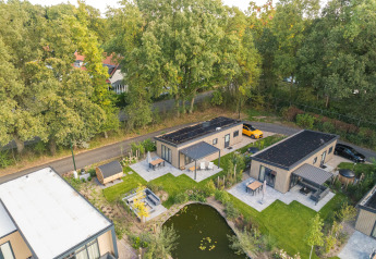 Luftaufnahme der Loevestein Deluxe Lodge mit Hottub & Sauna am Teich im Veluwepark de Bosgraaf, Niederlande.