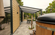 Outdoor terrace at Rosendael Comfort lodge with covered seating and hot tub in Veluwepark de Bosgraaf.