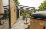 Outdoor terrace at Rosendael Comfort lodge with covered seating and hot tub in Veluwepark de Bosgraaf.