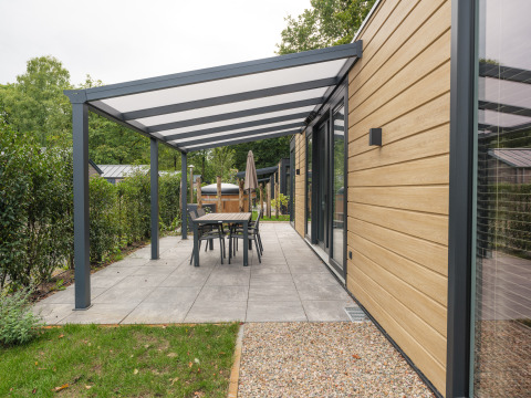 Moderne lodge met overdekt terras en eethoek bij Rosendael Comfort met hottub, Veluwepark de Bosgraaf, Nederland.