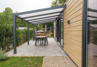 Moderne lodge met overdekt terras en eethoek bij Rosendael Comfort met hottub, Veluwepark de Bosgraaf, Nederland.