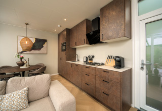 Cucina moderna e soggiorno nel lodge Rosendael Comfort con vasca idromassaggio al Veluwepark de Bosgraaf.