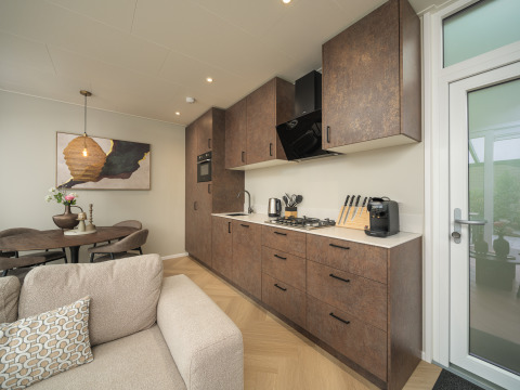Modern kitchen and living space in Rosendael Comfort lodge with hot tub at Veluwepark de Bosgraaf, Netherlands.