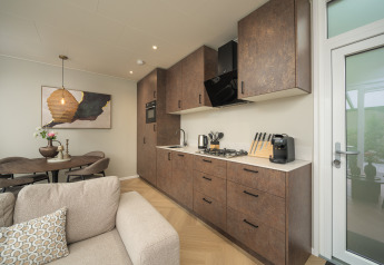 Modern kitchen and living space in Rosendael Comfort lodge with hot tub at Veluwepark de Bosgraaf, Netherlands.