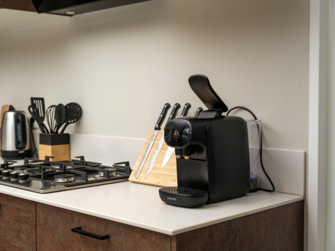 Angolo cucina moderno di Rosendael Comfort con macchina da caffè, coltelli e fornello a Veluwepark de Bosgraaf.