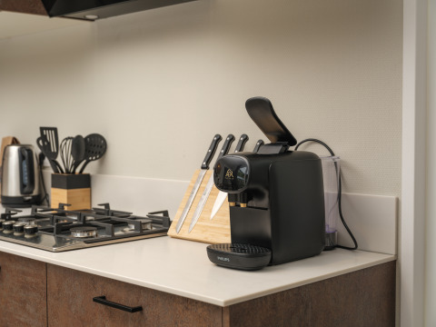 Moderne keukenhoek bij Rosendael Comfort met koffiemachine, messen en fornuis op Veluwepark de Bosgraaf.