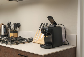 Moderne keukenhoek bij Rosendael Comfort met koffiemachine, messen en fornuis op Veluwepark de Bosgraaf.