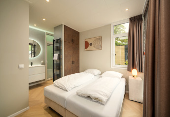 Dormitorio moderno en Rosendael Comfort con cama doble y baño en suite en Veluwepark de Bosgraaf, Países Bajos.