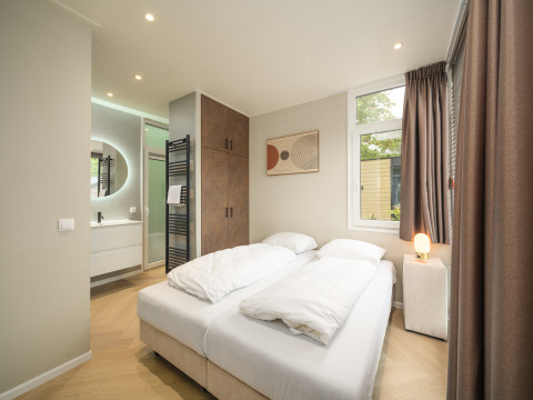 Moderne slaapkamer van Rosendael Comfort met dubbel bed en eigen badkamer in Veluwepark de Bosgraaf, Nederland.