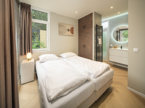 Moderne slaapkamer in Rosendael Comfort met hottub in Veluwepark de Bosgraaf, Nederland, lichte inrichting.