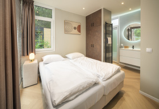 Modernes Schlafzimmer im Rosendael Comfort mit Whirlpool im Veluwepark de Bosgraaf, Niederlande, mit heller Einrichtung.