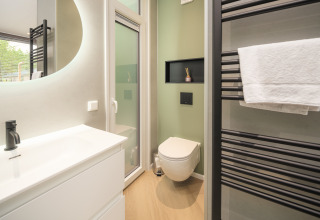 Baño moderno en Rosendael Comfort con inodoro suspendido y toallero en Veluwepark de Bosgraaf, Países Bajos.
